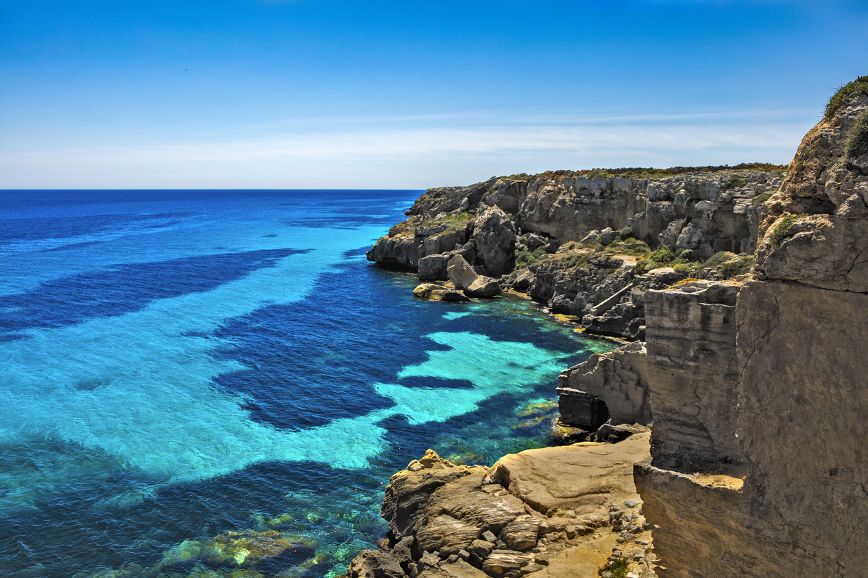 The magical shoreline of Favignana juts out of the blue and aqua water of the Mediterranean Sea.